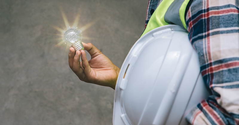 Professional engineer holding helmet and light bulbs with sunlight for creative new ideas and inspiration.