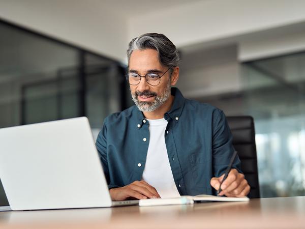 Middle aged older professional business man using laptop working