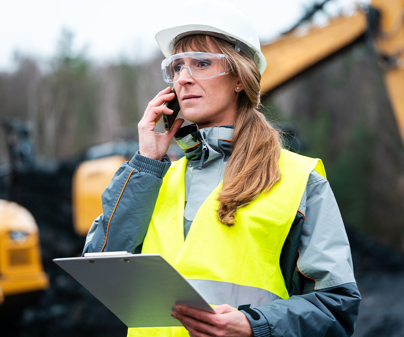 woman engineer in open-cast mining using phone