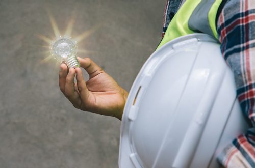 Professional engineer holding helmet and light bulbs with sunlight for creative new ideas and inspiration.