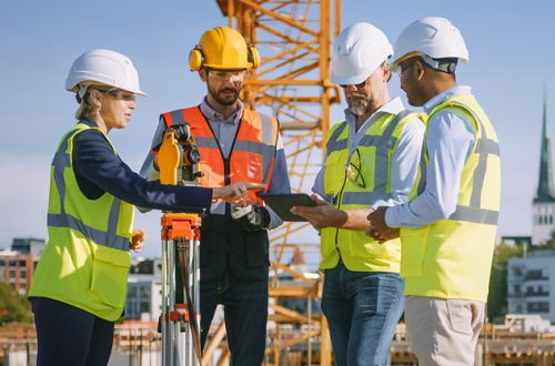 Diverse Team of Engineers Use Tablet Computer on Construction Site.