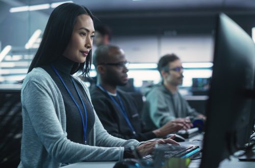 Young Asian Female Software Developer Working on Computer Together with Diverse Creative Colleagues. Data Protection Center with Servers, Storage Hardware and Cyber Security Research