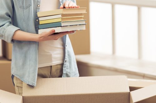 Cropped-image-of-young-woman-moving-and-packing-books