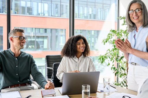 Senior-female-executive-and-multicultural-business-people-discuss-corporate-project-at-boardroom-table