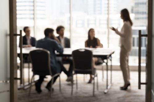 Silhouettes-of-businesspeople-gathered-in-conference-room
