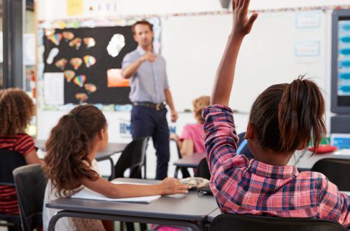 Teacher-pointing-to-elementary-school-student-in-class